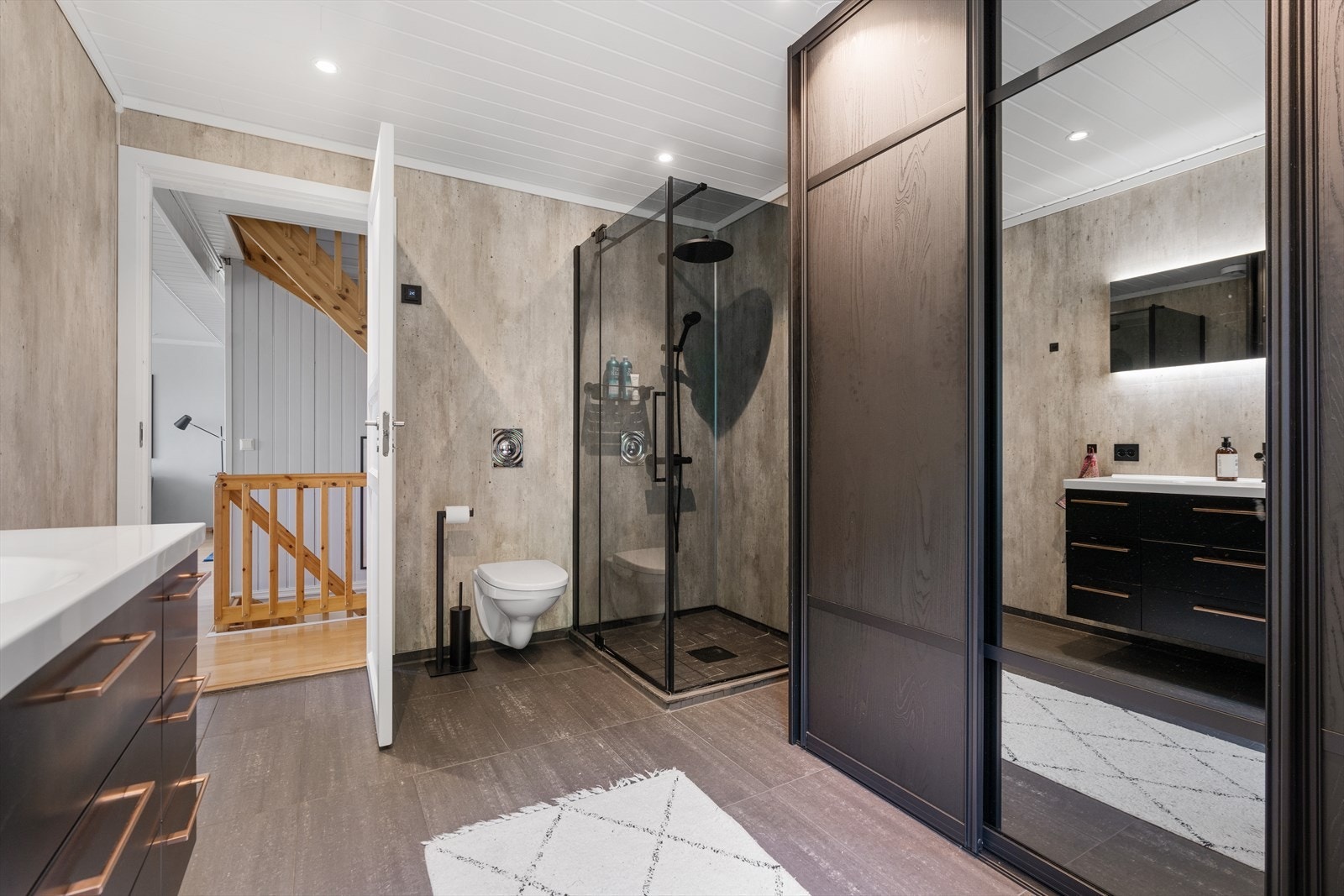 Badet er utstyrt med regnfallsdusj i dusjnisjen, og det er gode oppbevaringsmuligheter i innredningen. Galleribilde