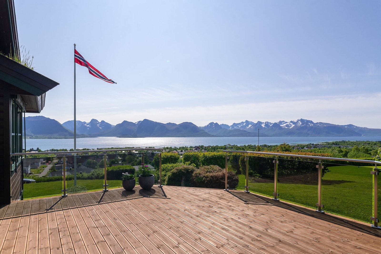 Romslig og solrik terrasse med glassrekkverk som lar deg nyte meget flott og uhindret utsikt mot sjø og fjell. Galleribilde