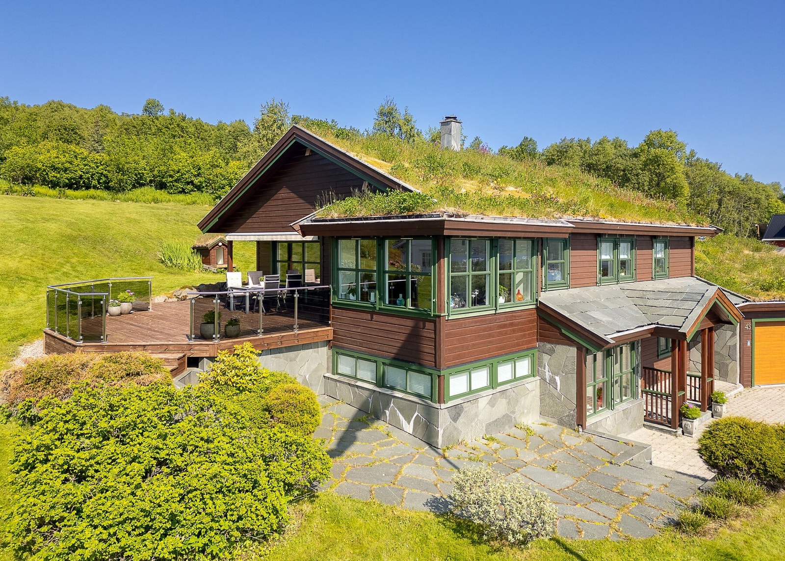 Romslig tomt med flott opparbeidet uteareal. Frodig hageområde med stor plen, trær og beplantning. Galleribilde