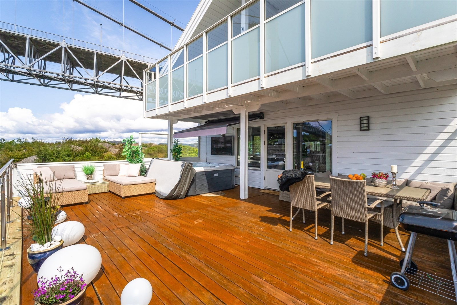 Det er god plass til ønsket innredning med både sittegruppe, solsenger, grill, spisebord, blomsterkasser mm. Elektrisk styrt markise over jacuzzien. Galleribilde