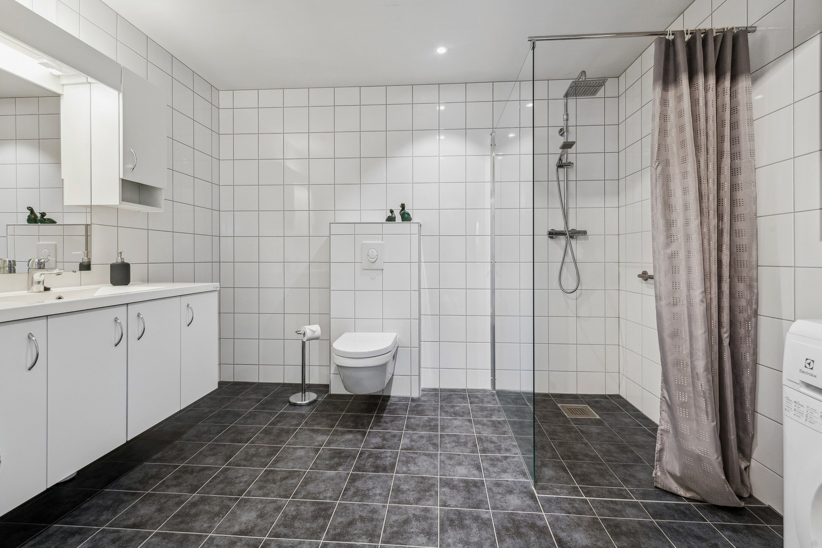Helfliset bad med nedsenket dusj, vegghengt toalett og godt med oppbevaringsplass. Galleribilde