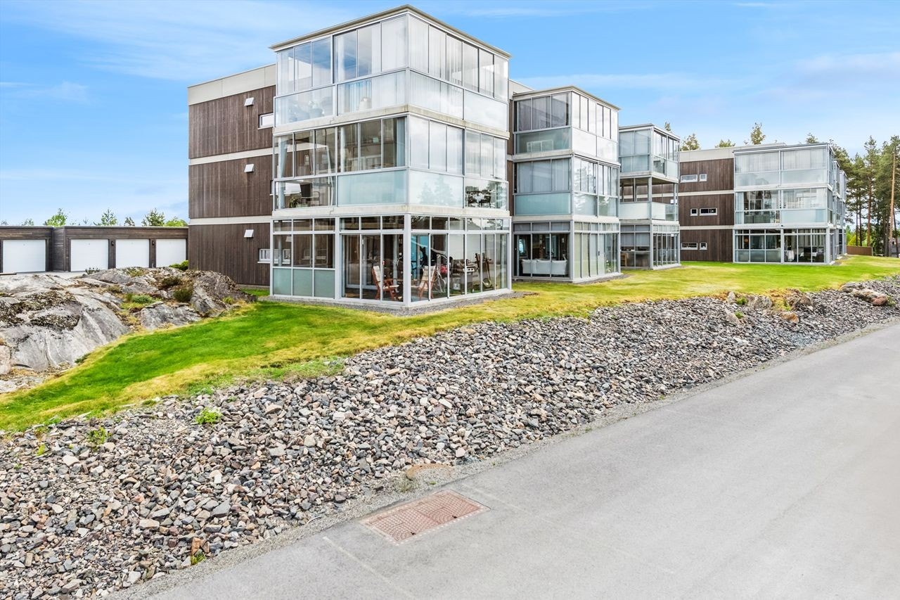 Velholdt lavblokk med moderne fasade og innbydende fellesarealer i rolige omgivelser. Galleribilde