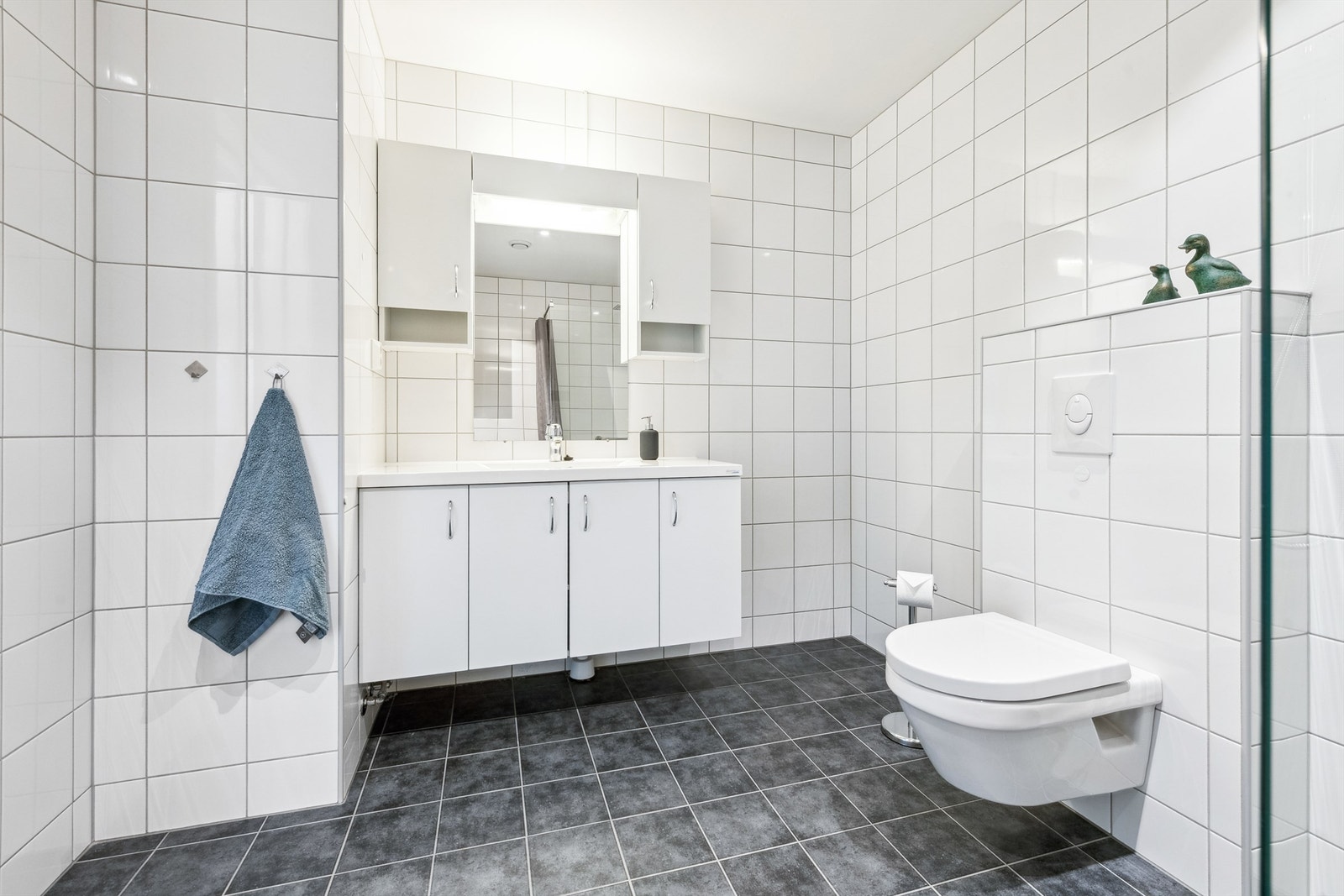 Badet har heldekkende servant, integrert belysning og opplegg for vaskemaskin. Galleribilde