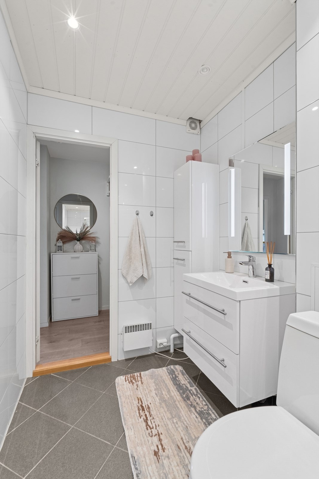 Badet har hvit innredning med praktiske skuffer og sideskap. Speil med innfelt lys. Nytt dusjkabinett og opplegg til vaskemaskin. Galleribilde