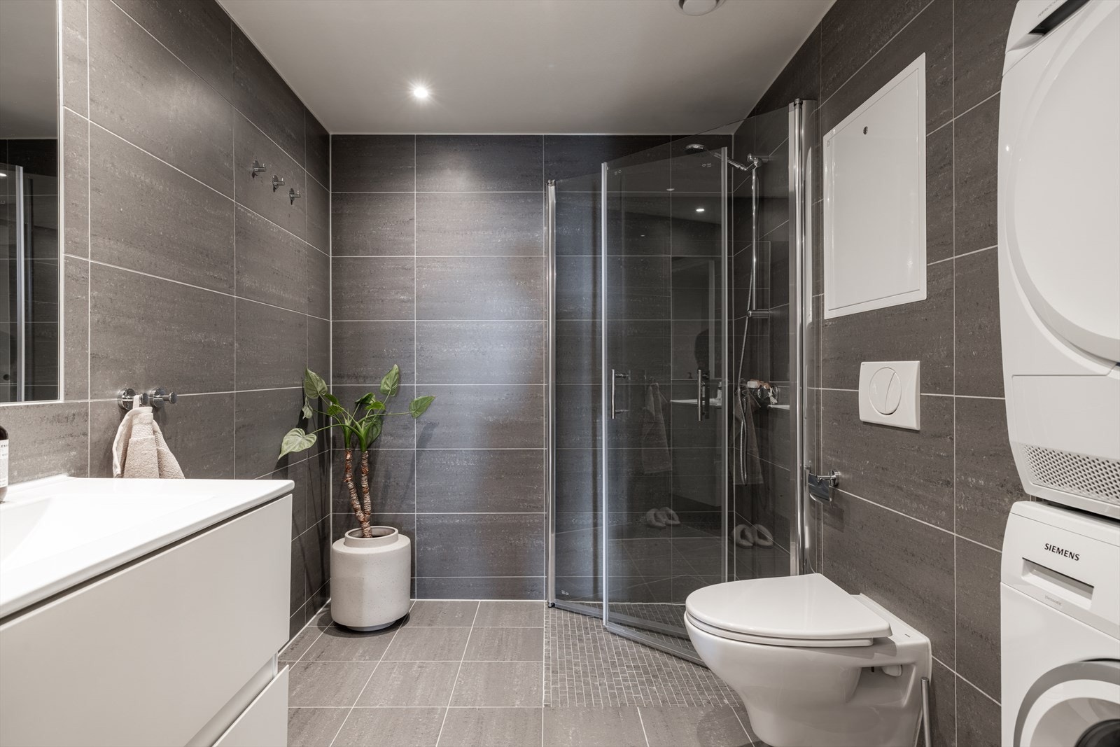 Lekkert baderom med opplegg for vaskemaskin og plass til tørketrommel. Galleribilde