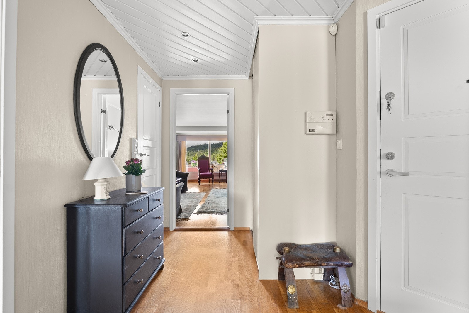 Vel inne passer det fint å innrede med knagger og skohyller i en entré med parkett på gulvet. Entreen har downlights, dørcallinganlegg og vegger holdt i en lys gråtone Galleribilde