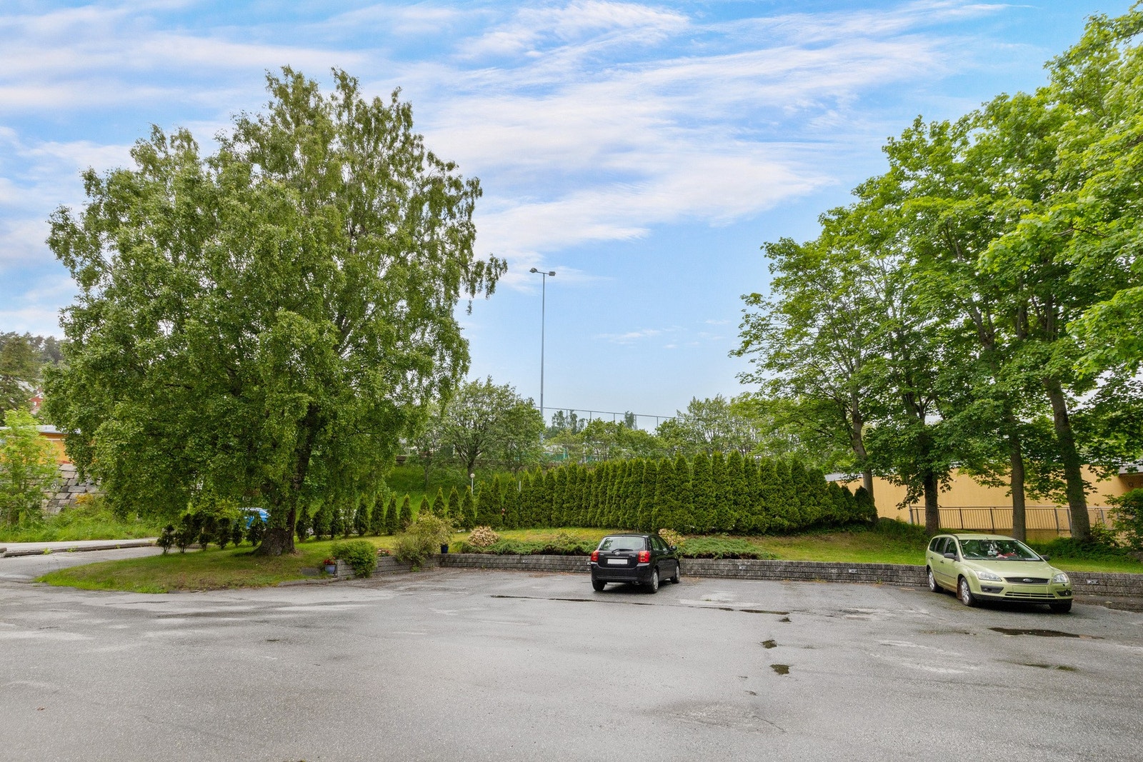 Parkeringsareal for bygget. Denne leiligheten har egen merket p-plass med elbillader. Galleribilde