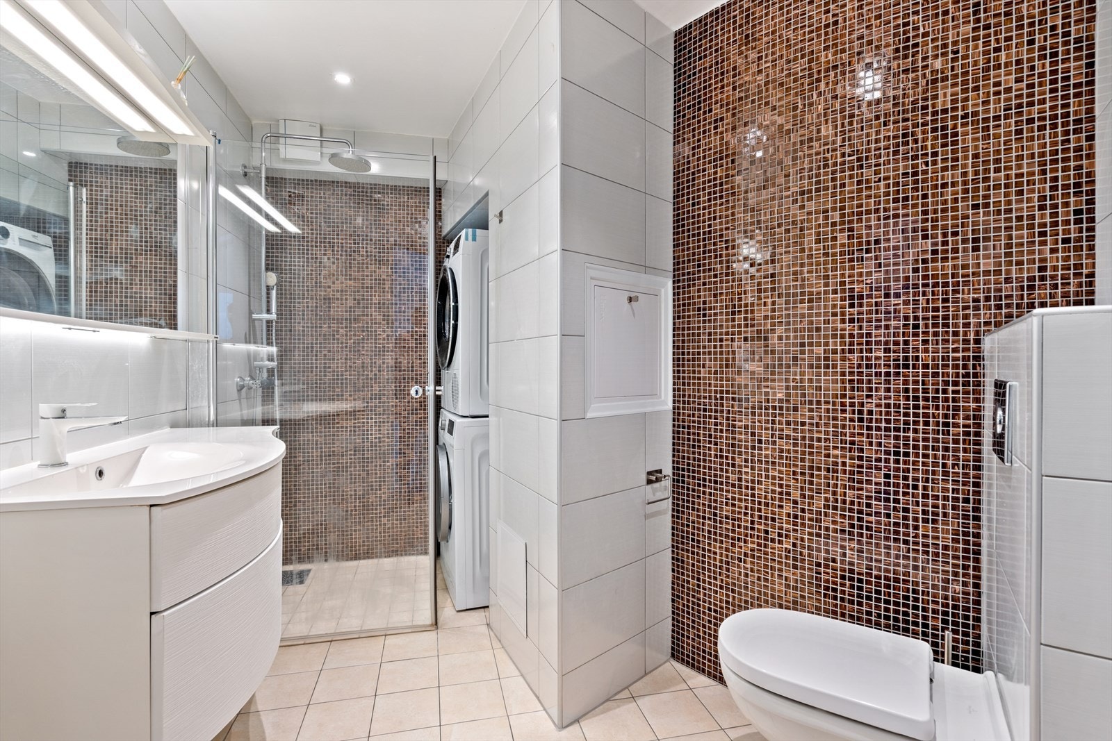 Pent flislagt bad fra 2016 med dusjhjørne, vegghengt wc, servantinnredning og opplegg for vasketårn Galleribilde