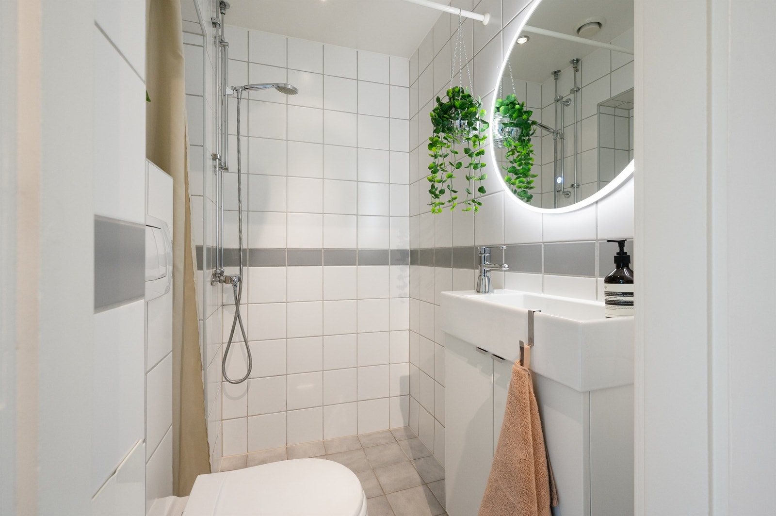 Badet er innredet med vegghengt klosett, servant nedfelt i innredning og dusjhjørne. Galleribilde