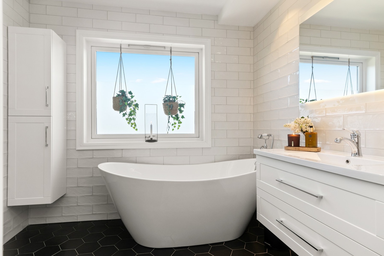 Bad pusset opp i 2017 av tidligere eier. Veggene er flislagt med lyse, glansede fliser i mursteinsmønster, og gulvet har moderne, mørke hexagonfliser. Galleribilde