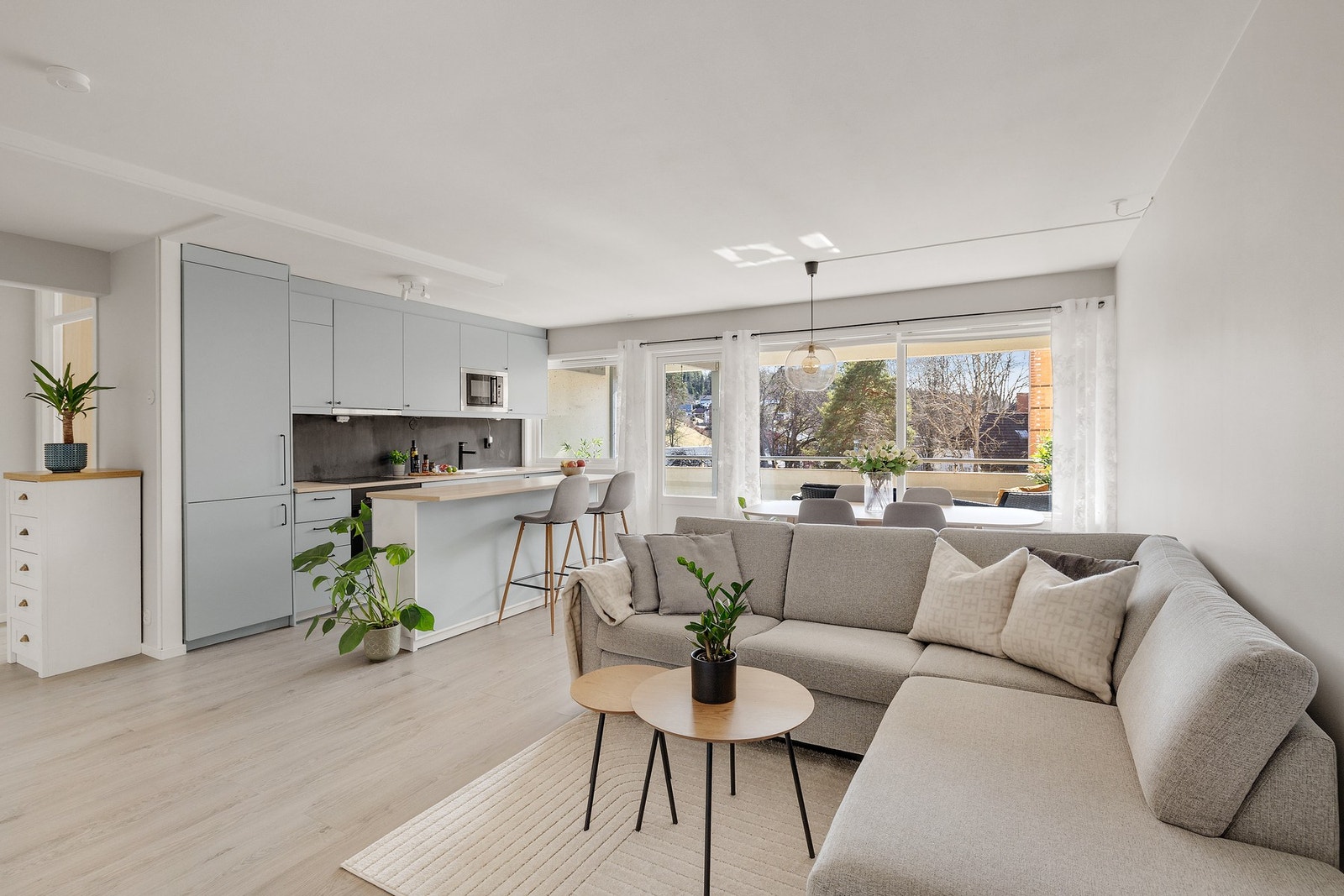 Romslig stue/kjøkkenløsning som er malt i delikat farge i 2025. Galleribilde