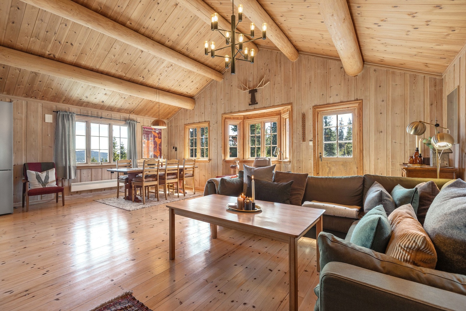 Lys og trivelig stue med lakkert tregulv og panelerte vegger og tak Galleribilde