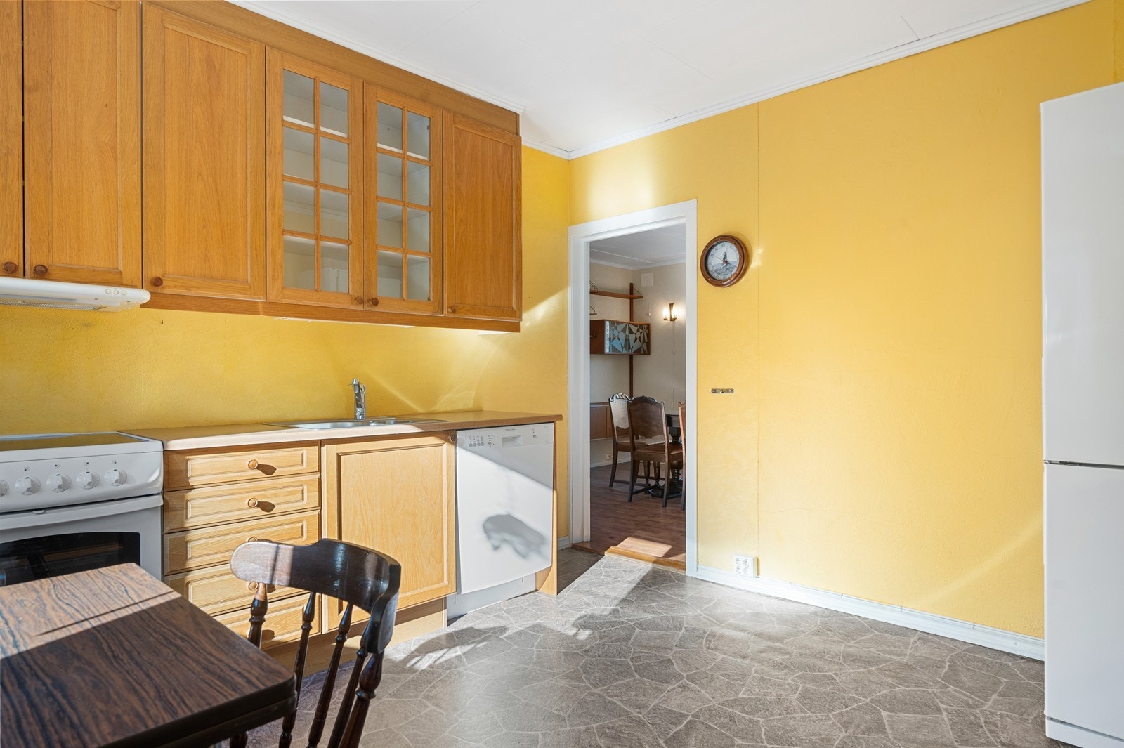 Eldre eikekjøkken med komfyr og oppvaskmaskin samt laminert benkeplate Galleribilde