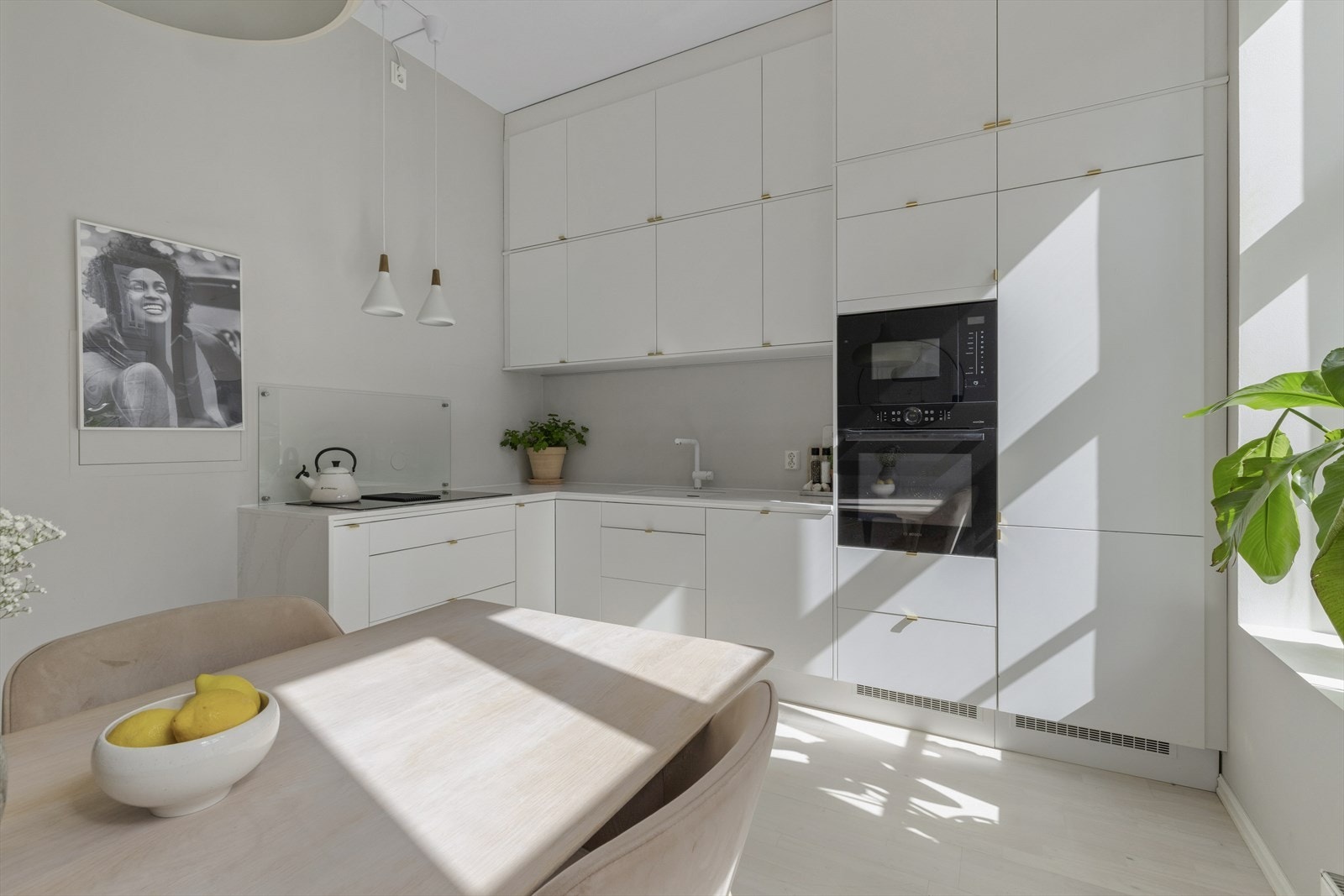 Kjøkkeninnredning med hvite fronter og benkeplate av stein med nedfelt oppvaskkum med 1-greps blandebatteri. Innredningen er fra Epoq og benkeplate fra Nerostein. Galleribilde