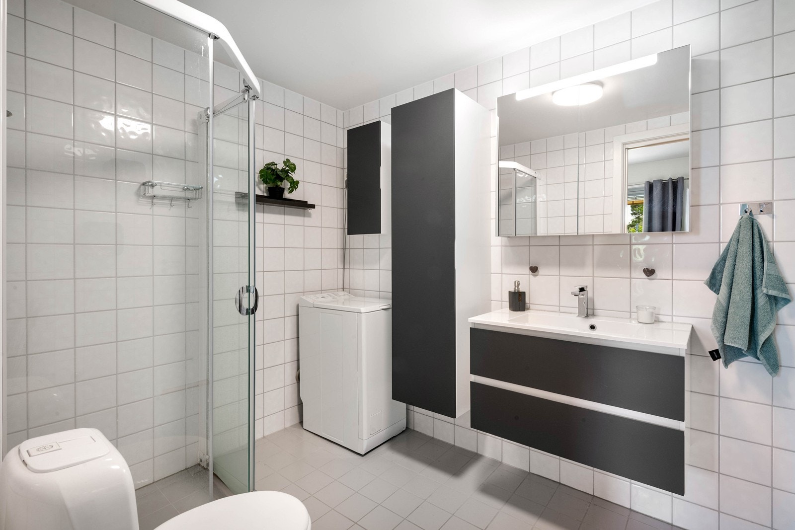 Lyst og pent bad med opplegg for vaskemaskin Galleribilde