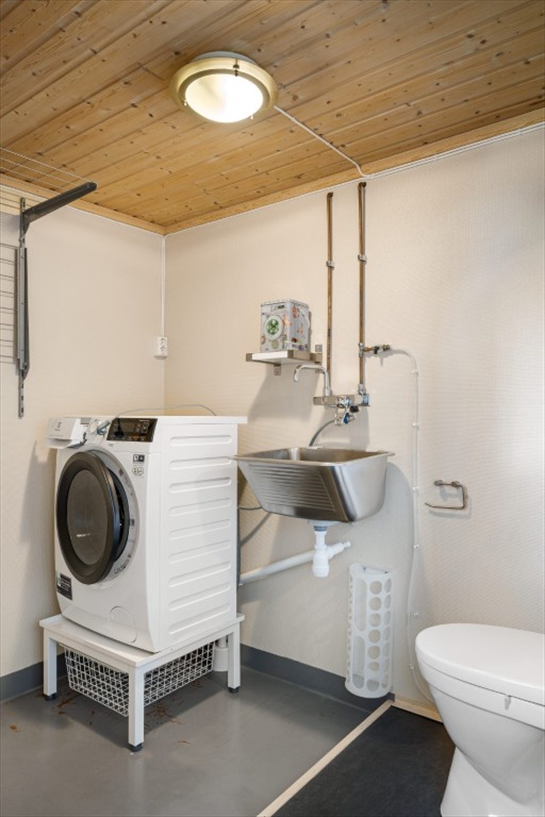 Praktisk vaskerom i kjelleren med utslagsvask og plass til vaskemaskin. Det er også satt inn et ekstra toalett i rommet Galleribilde