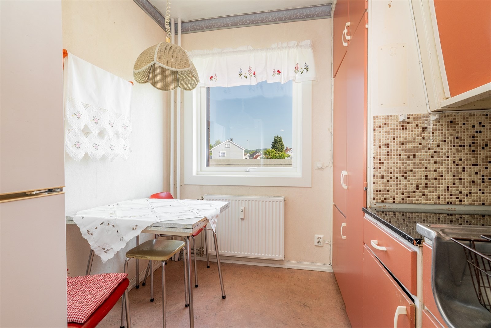 Overflater består av belegg på gulv, vegger er av tapet med små mosaikkflis på vegg over kjøkkenbenk. Taket er malt. Galleribilde