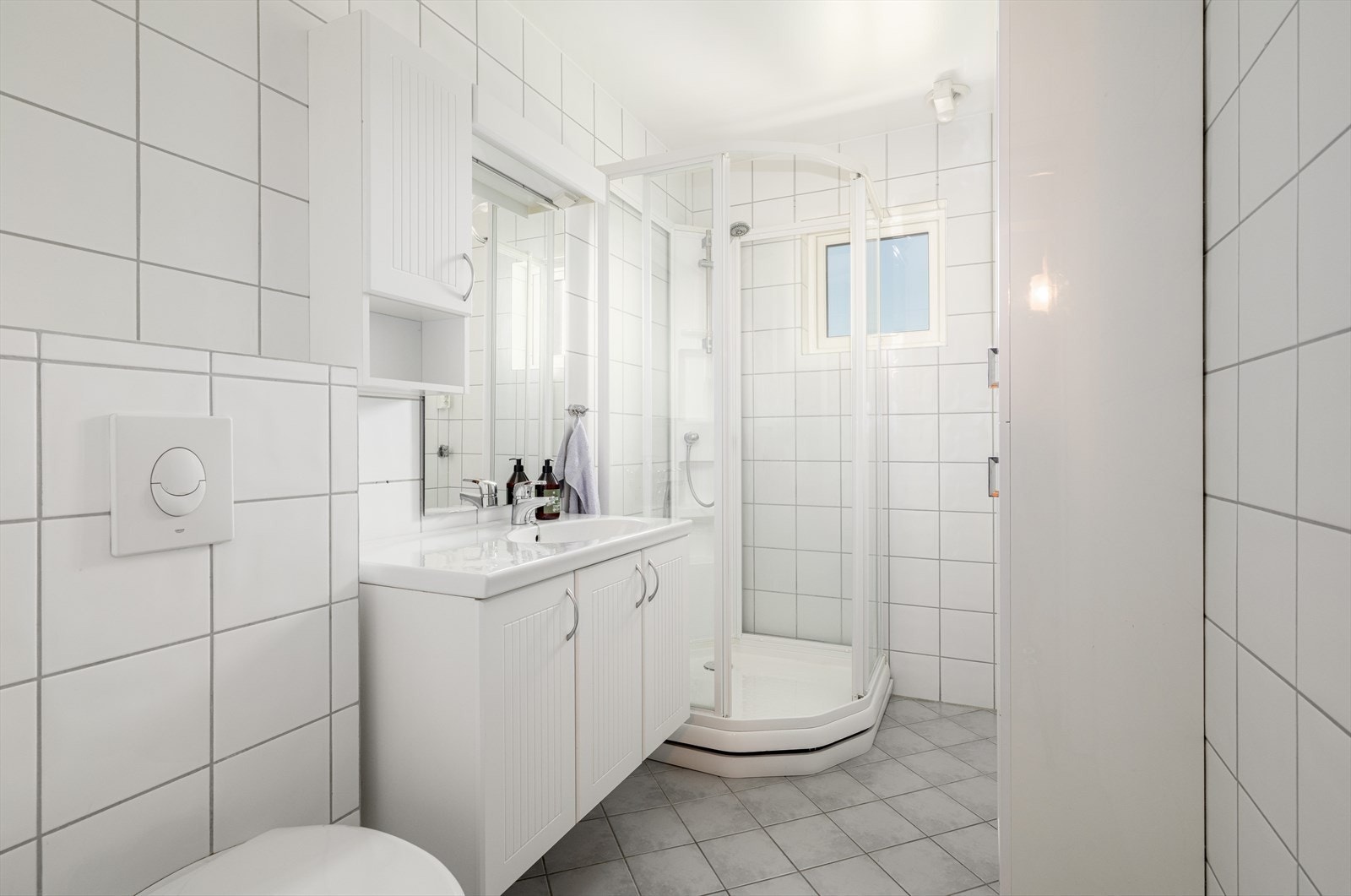 Lyst, flislagt bad pusset opp i regi av borettslaget i 2010. Badet er utstyrt med gulvvarme, vegghengt toalett og dusjkabinett, samt opplegg for vaskemaskin og tørketrommel. Galleribilde