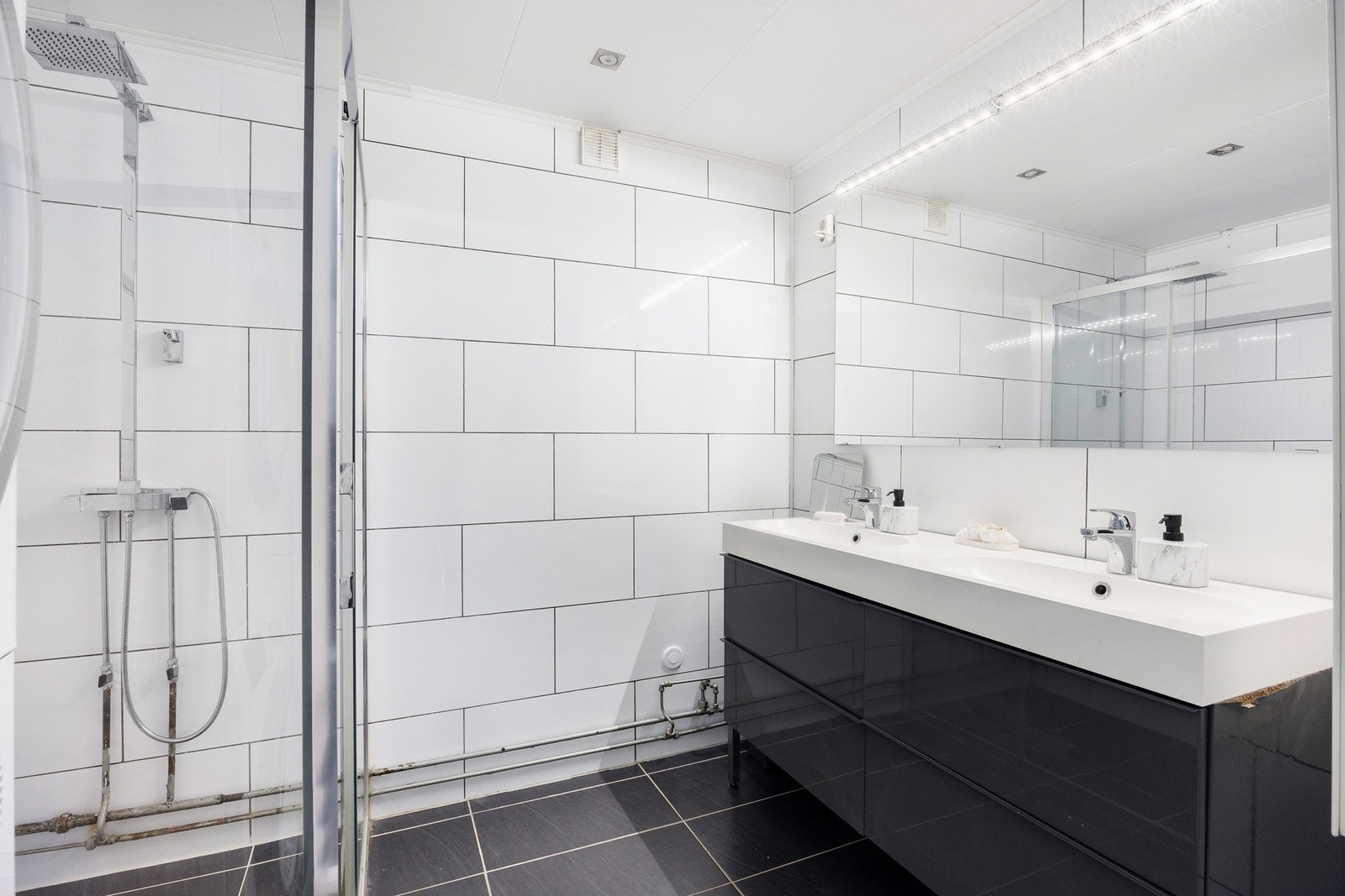 Flislagt bad med dusjnisje og dobbelt servant. Galleribilde