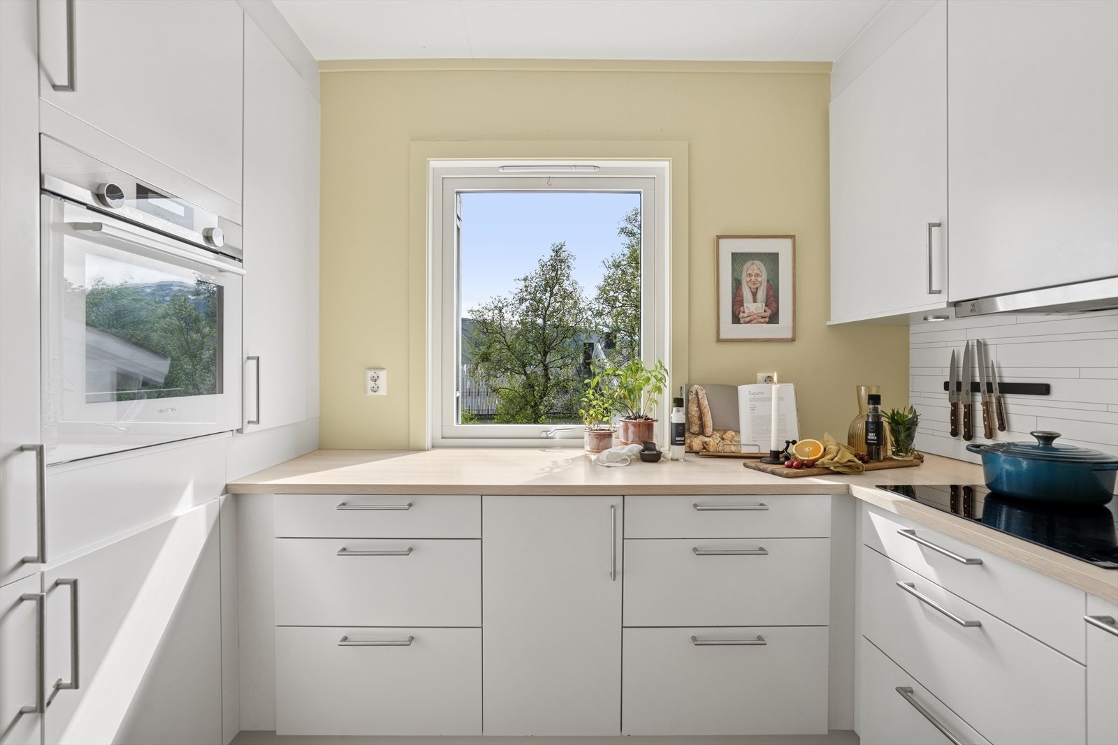 Leiligheten har et moderne og pent kjøkken med hvite fronter og en fin benkeplate som har god plass til matlaging. Galleribilde