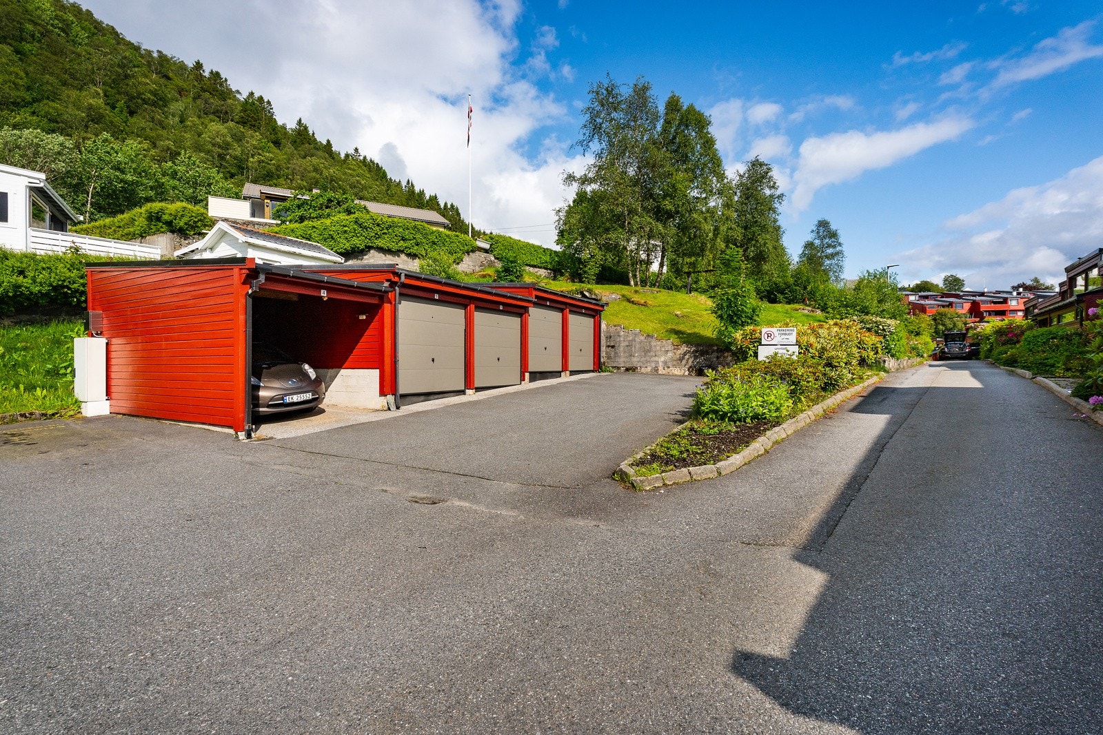Gjesteparkering ved siden av garasjene. Huset ligger like inne i veien. Merk at garasjen som tilhører huset ligger i den andre enden av veien, dette er nærmere huset. Galleribilde