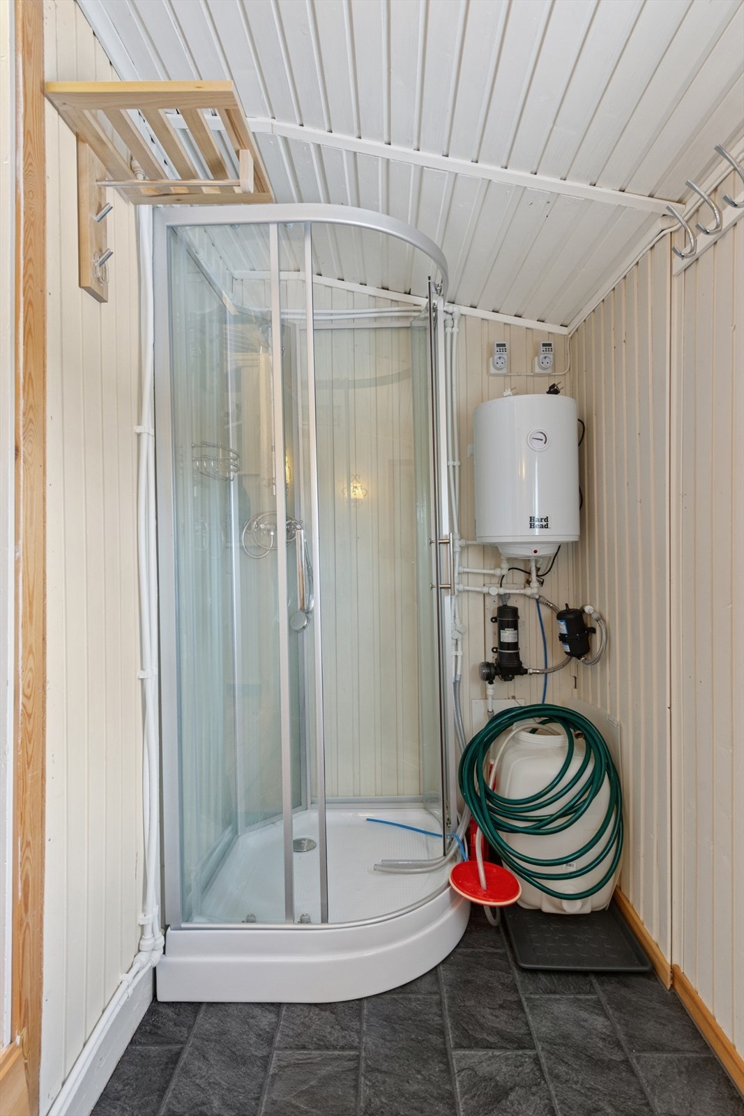 Liten bereder montert på vegg ved dusjkabinett fra 2024, som fylles etter behov. Galleribilde