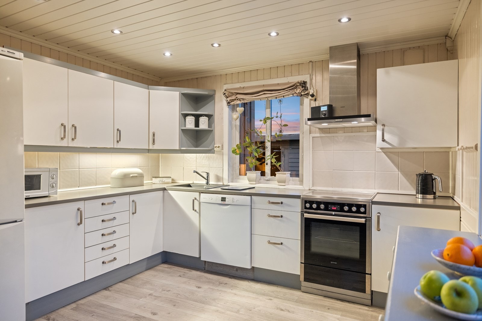 Kjøkkeninnredningen er fra ca. år 2000 og er utført med hvite, glatte fronter og laminat benkeplate med komposittkum. Galleribilde