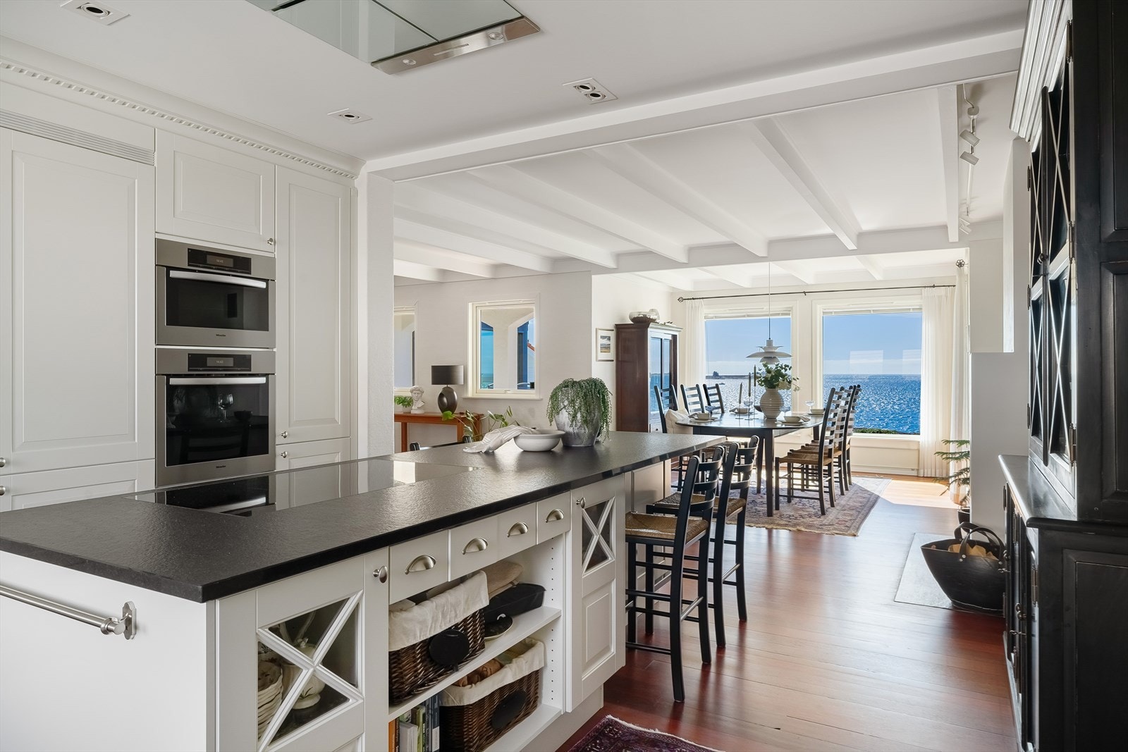 Spisestuen som er en del av kjøkkenrommet, gir plass til en stor spisegruppe og nyter fantastisk sjøutsikt takket være store vindusflater. Galleribilde