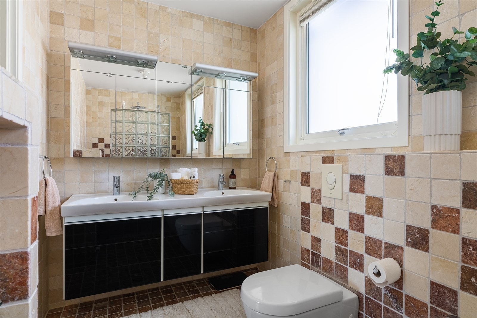 Helfliset bad med dobbelservant, speil, veggmontert toalett, bidé og dusjhjørne. Galleribilde