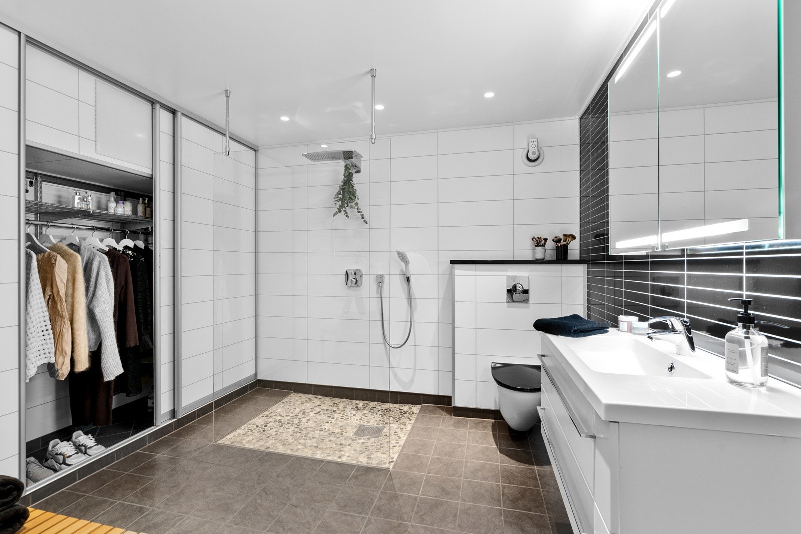 Bad i underetasjen fra 2011 med gulvvarme, vegghengt klosett, skyvedørsgarderobe og regndusj med fliser og elvestein. Galleribilde