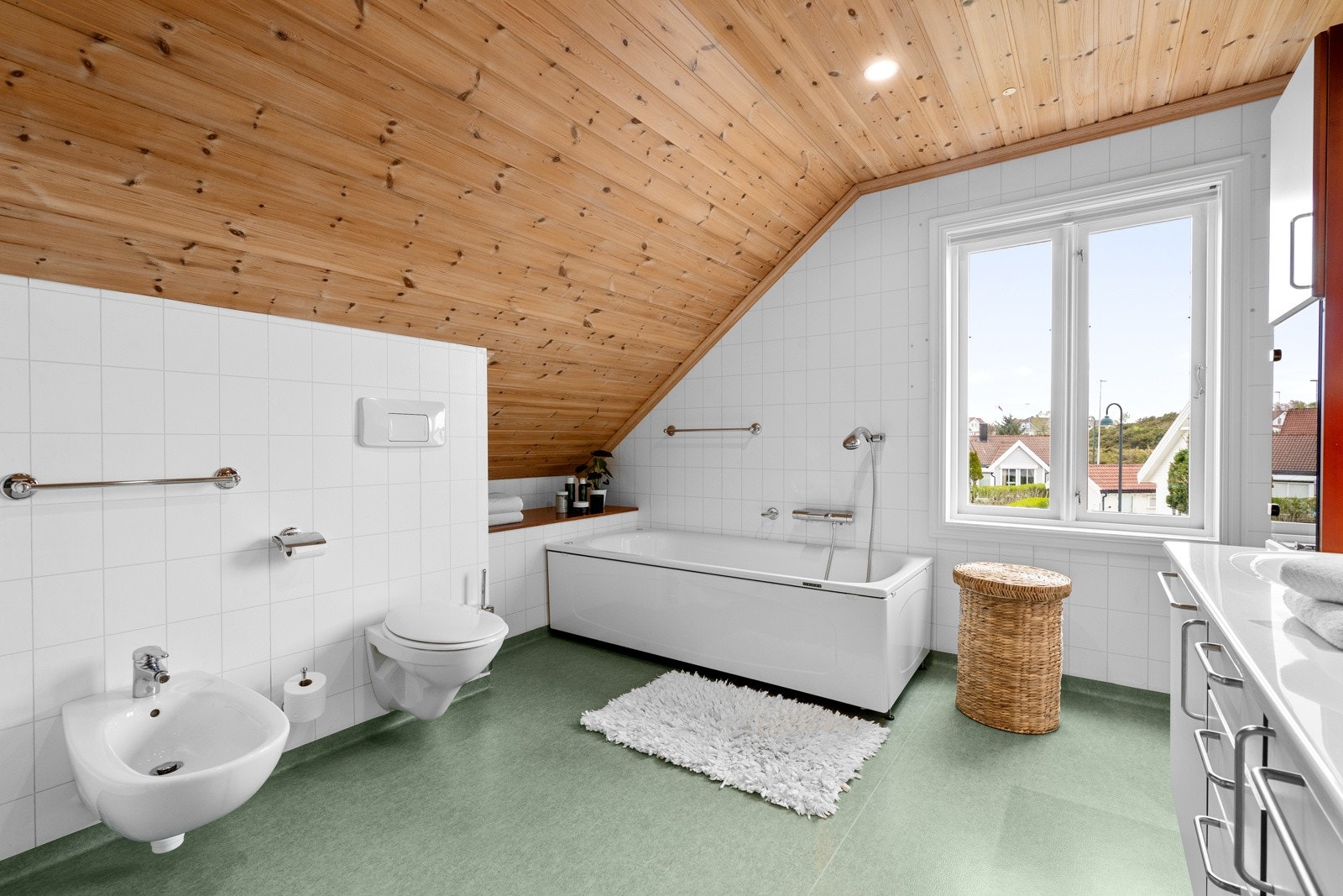 Innredet med stort badekar, vegghengt bidé, toalett og stor dusjnisje. Galleribilde