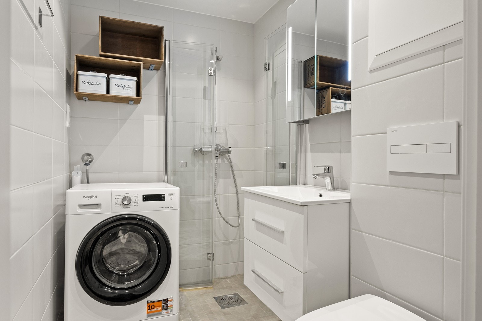 Badet ble oppgradert i regi av borettslaget i 2020 og fremstår moderne og funksjonelt. Rommet har grå gulvfliser med gulvvarme, hvite veggfliser og slett hvitt tak med innfelte spotter. Hvit innredningen med heldekkende servant, skuffer for oppbevaring. Galleribilde