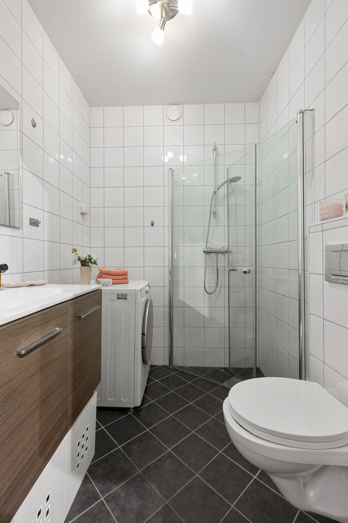 Badet er utstyrt med dusjhjørne, servantinnredning, toalett og opplegg for vaskemaskinen. Galleribilde