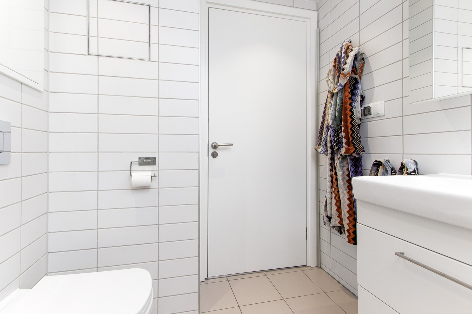 Badet er videre utstyrt med hvit skuffeseksjon, heldekkende servant og et speilskap. Galleribilde