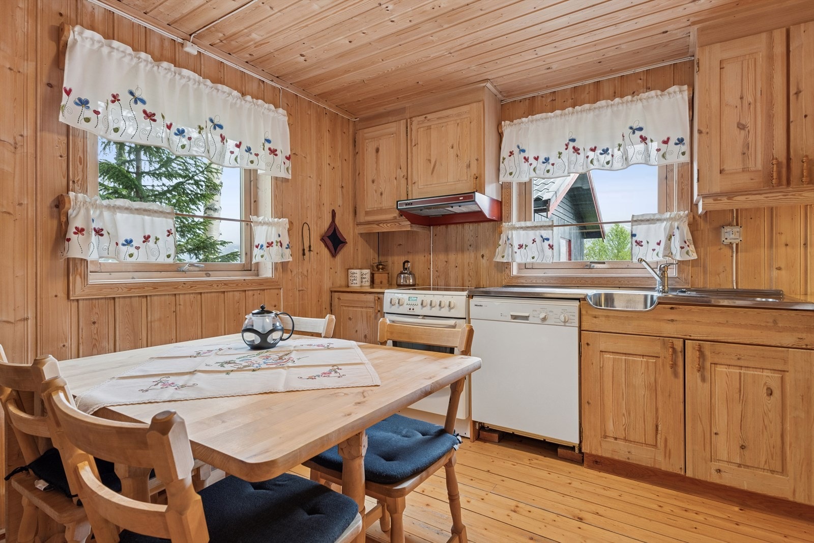 Et stort vindu over oppvaskbenken gir rikelig med naturlig lys og utsikt til uteområdet. Galleribilde