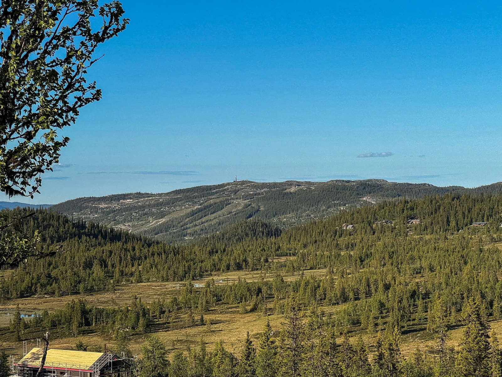 Man ser også rett mot alpinsenteret som lyser opp en ellers mørk vinterkveld Galleribilde