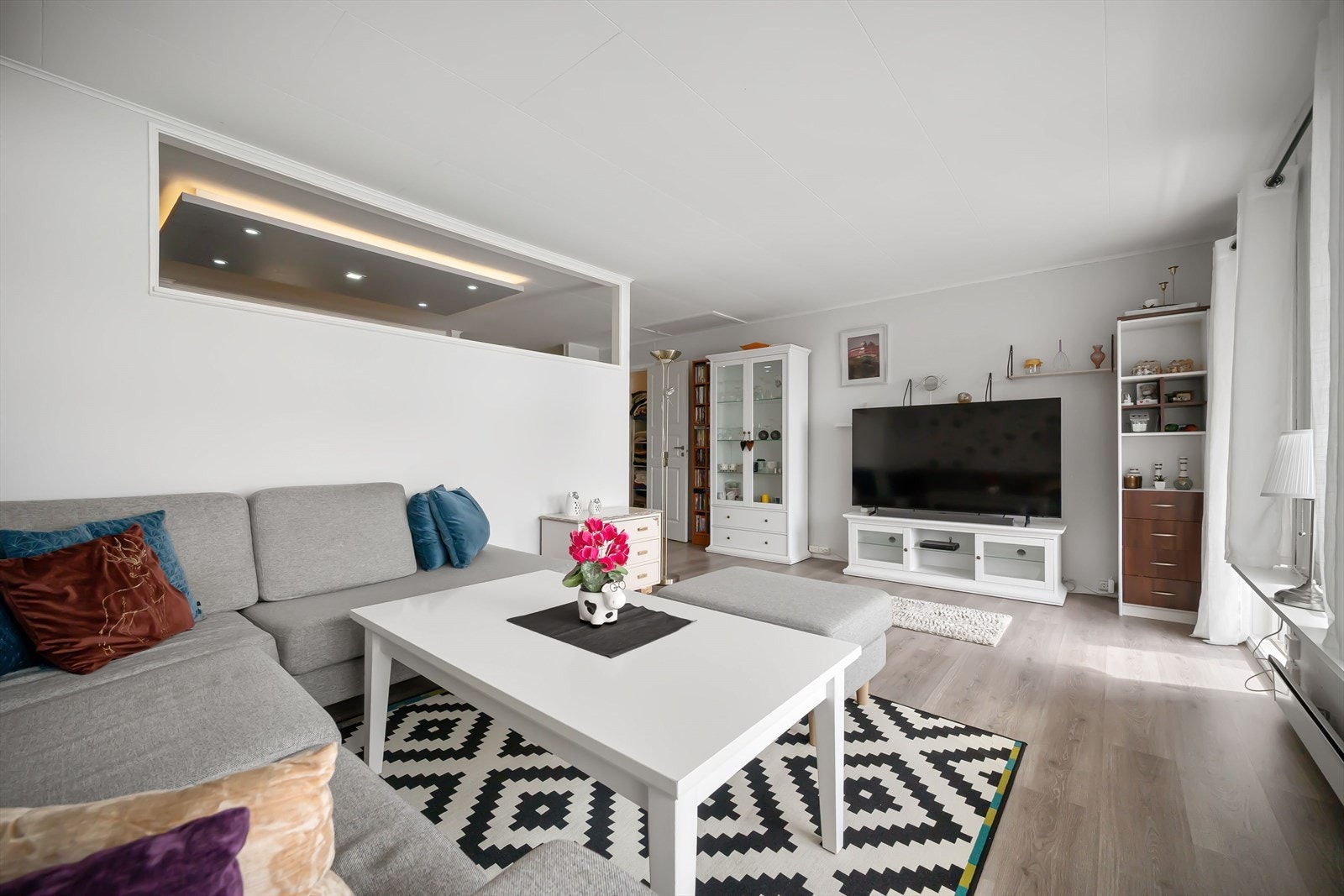Lys og romslig stue med store vinduer, moderne design og god plass til både avslapning og sosiale sammenkomster. Galleribilde