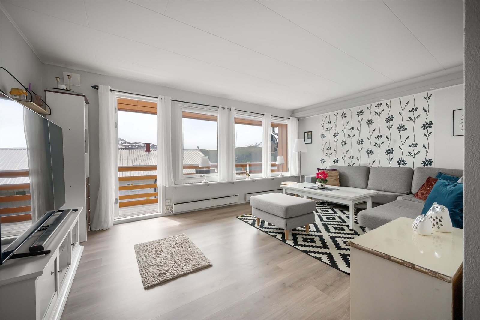 Lys og innbydende stue med store vinduer som slipper inn rikelig med naturlig lys. Galleribilde
