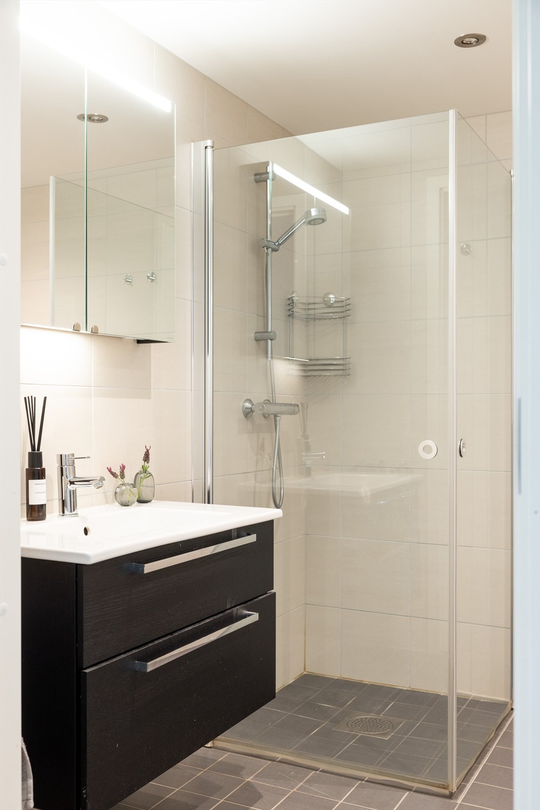 Badet er innredet med vegghengt klosett, servant på innredning og dusjvegger/hjørne. Galleribilde