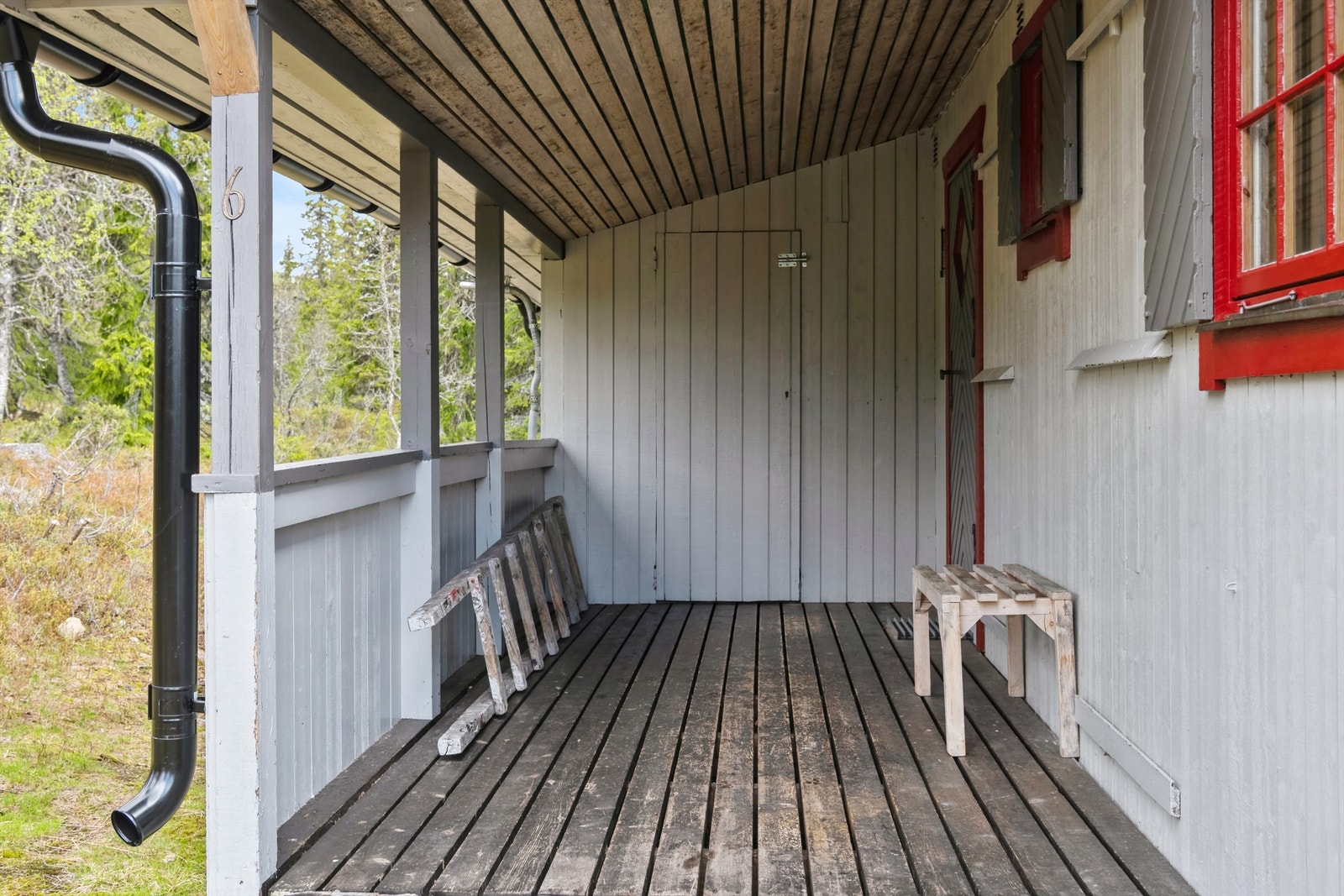 Overbygd inngangsparti med adkomst til hytte og tilbygg med boder og mulldo Galleribilde