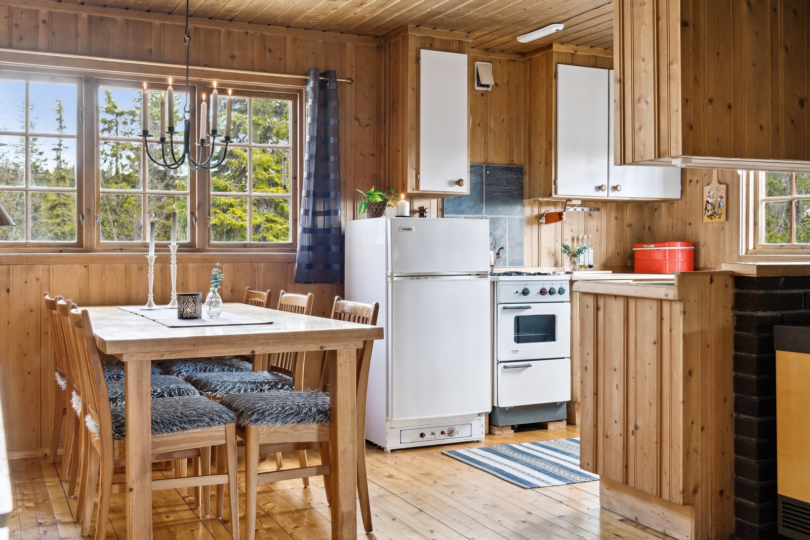 Praktisk og sosial kjøkkenløsning med spisebord til familie og venner Galleribilde