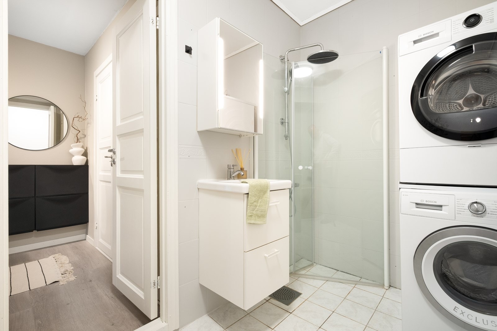 Badet er innredet med benkeskap med servant, dusj og opplegg for vaskemaskin. Galleribilde