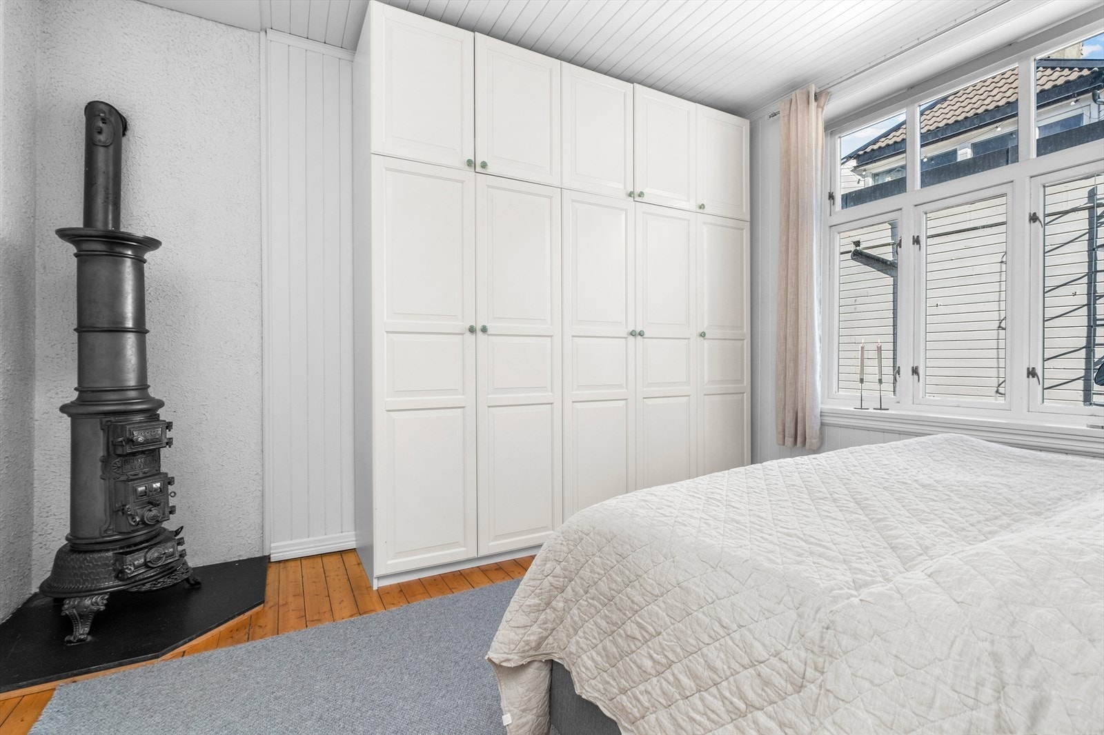 Soverommet byr på stort og flott garderobeskap for oppbevaring, samt en koselig klassisk gammeldags vedovn. Galleribilde