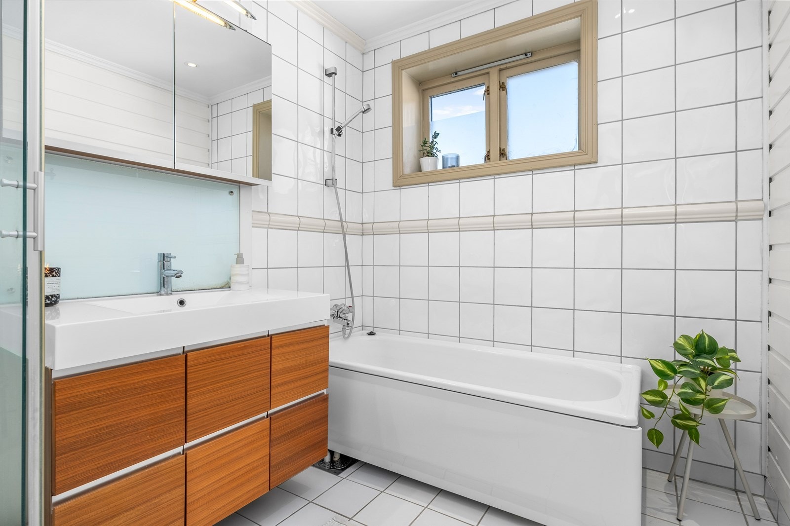 Badet er utstyrt med dusjkabinett, badekar, servantskap og mekanisk avtrekk. Galleribilde