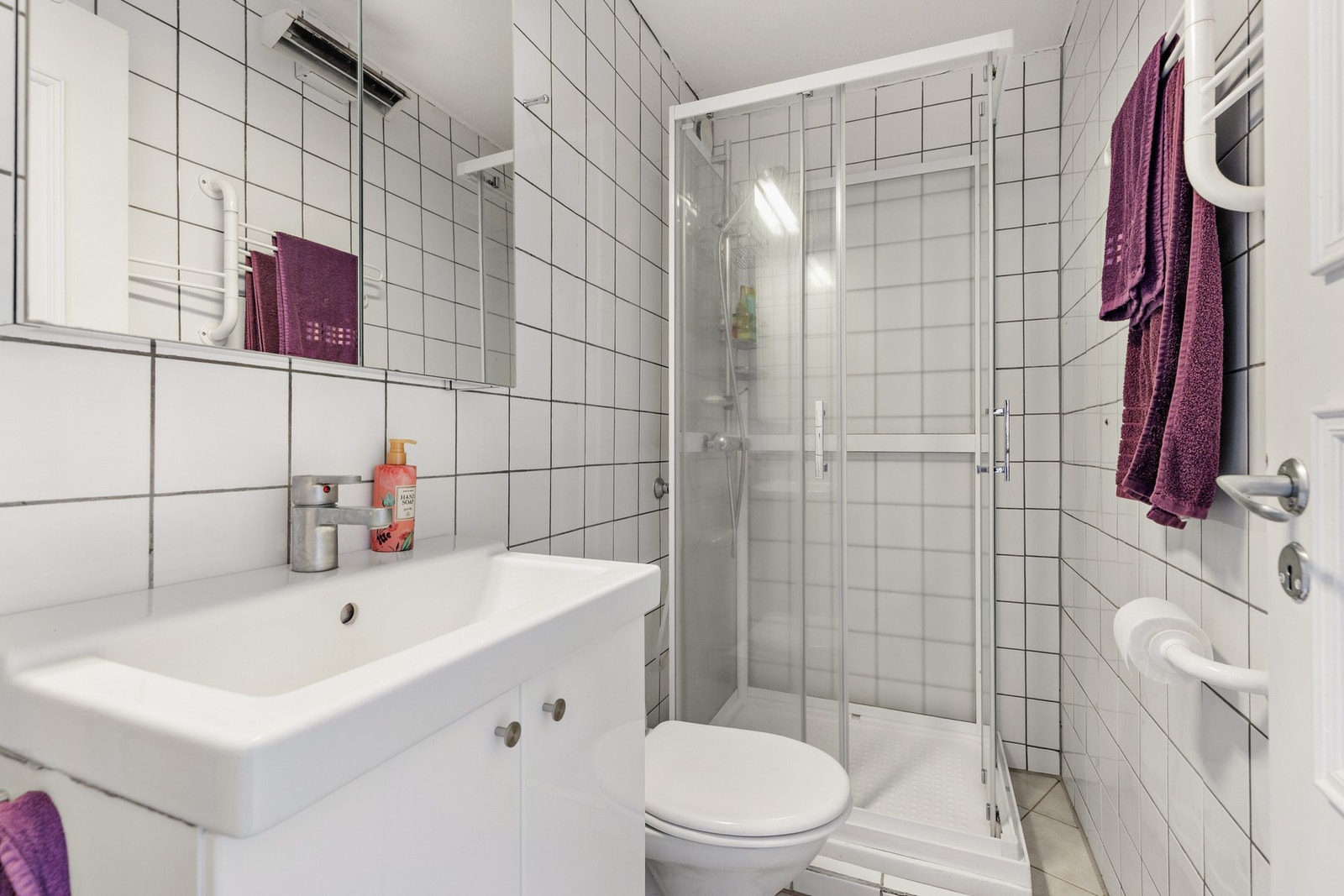 Badet er utstyrt med dusjkabinett med skyvedører og to-greps blandebatteri, samt et gulvstående toalett Galleribilde