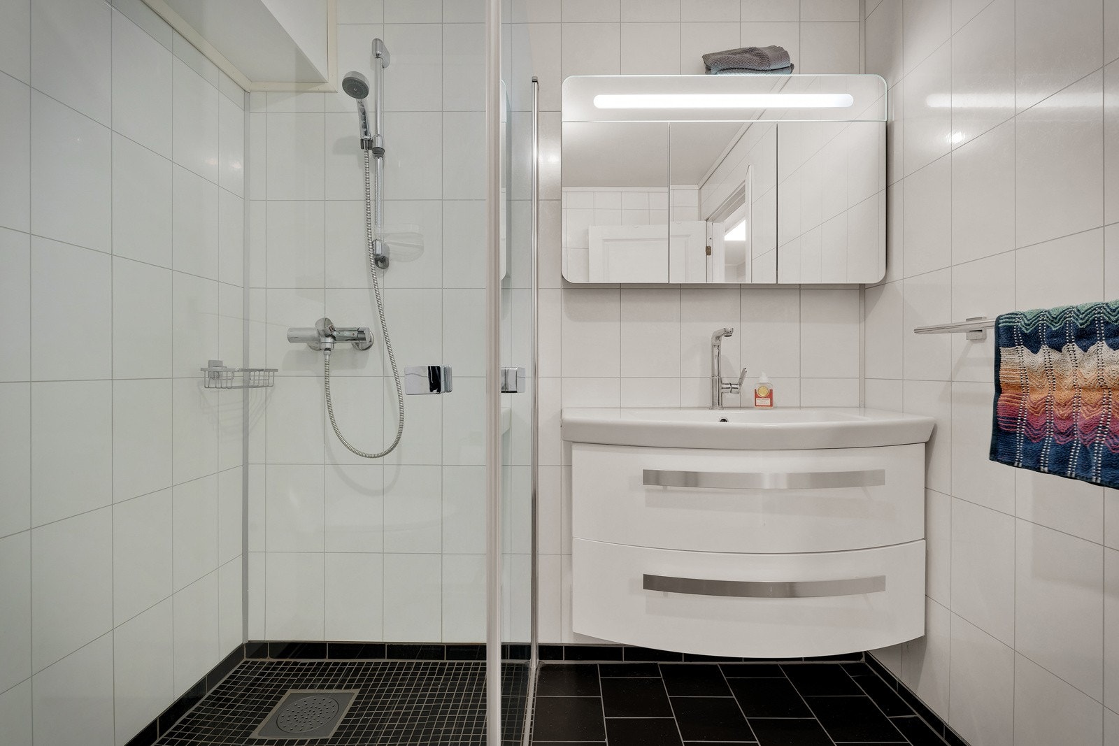 Innredet med nedfelt servant, veggmontert toalett og dusjvegger av glass. Galleribilde