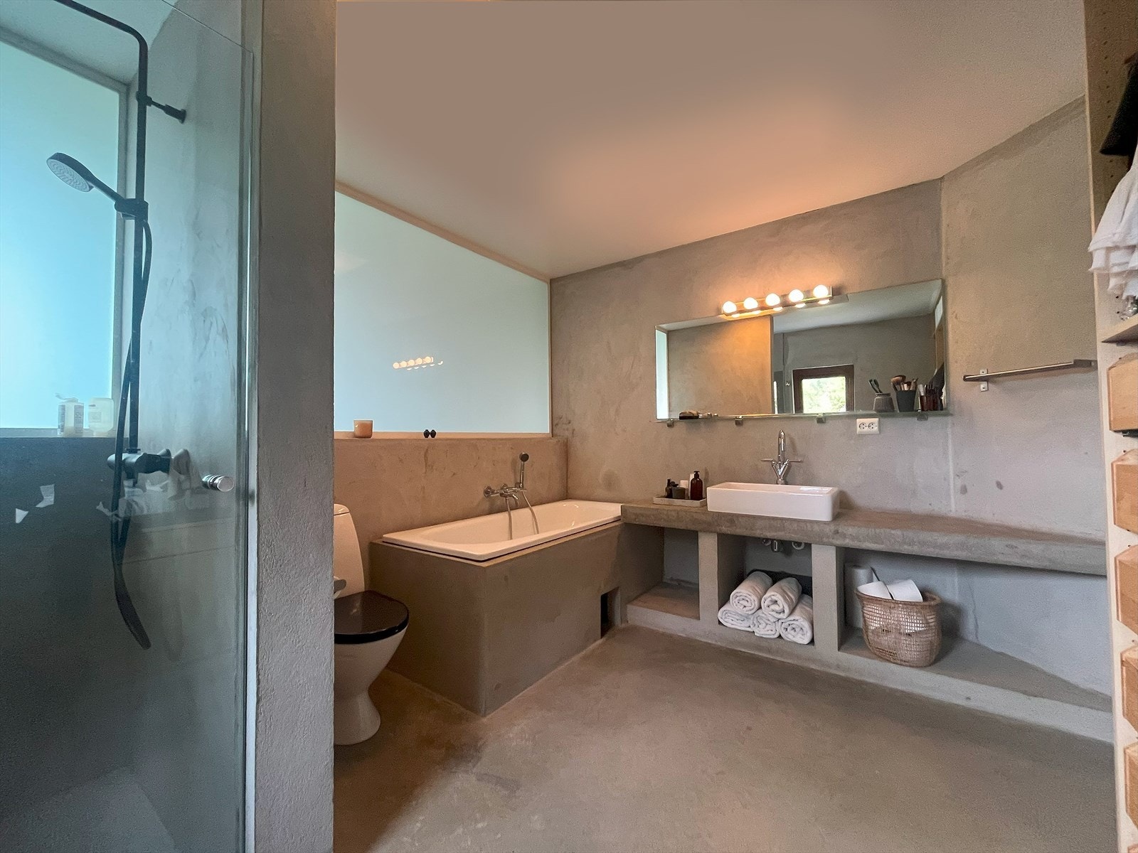 Moderne bad med dusjnisje, badekar, elegant belysning og stilrene detaljer. Praktisk oppbevaring under vasken gir et ryddig inntrykk. Galleribilde