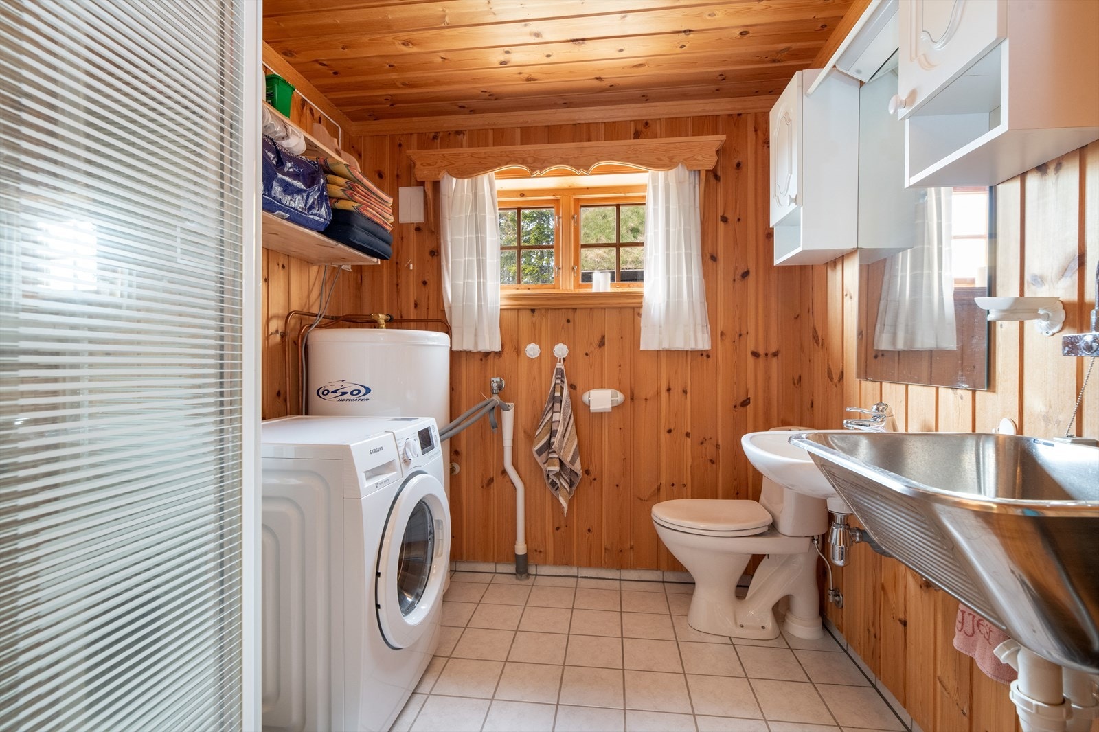 Hytta har eget vaskerom praktisk plassert ved inngangspartiet. Rommet har fliser på gulv med varmekabler, og panel på vegger og i tak. Vaskerommet er innredet med enkel servant, overskap med speil og lys, utslagsvask, toalett og opplegg for vaskemaskin. Galleribilde