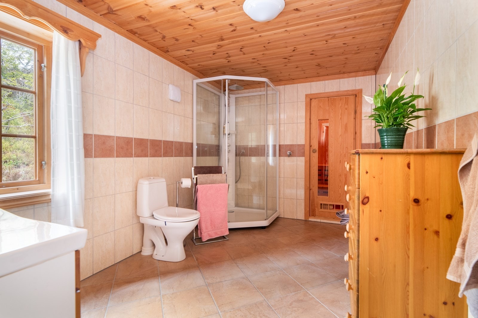 Badet er også innredet med dusjkabinett og toalett. Vannkran på vegg ved dusjkabinett. Avtrekksvifte på yttervegg. Galleribilde