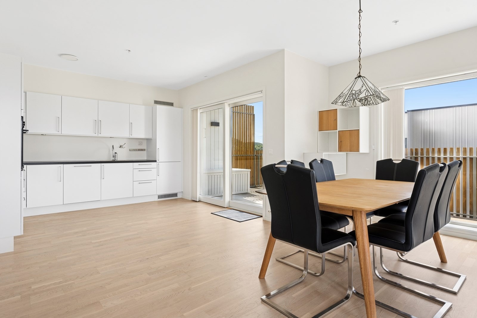 Moderne kjøkken med glatte, hvite fronter og en slitesterk benkeplate av laminat. Galleribilde